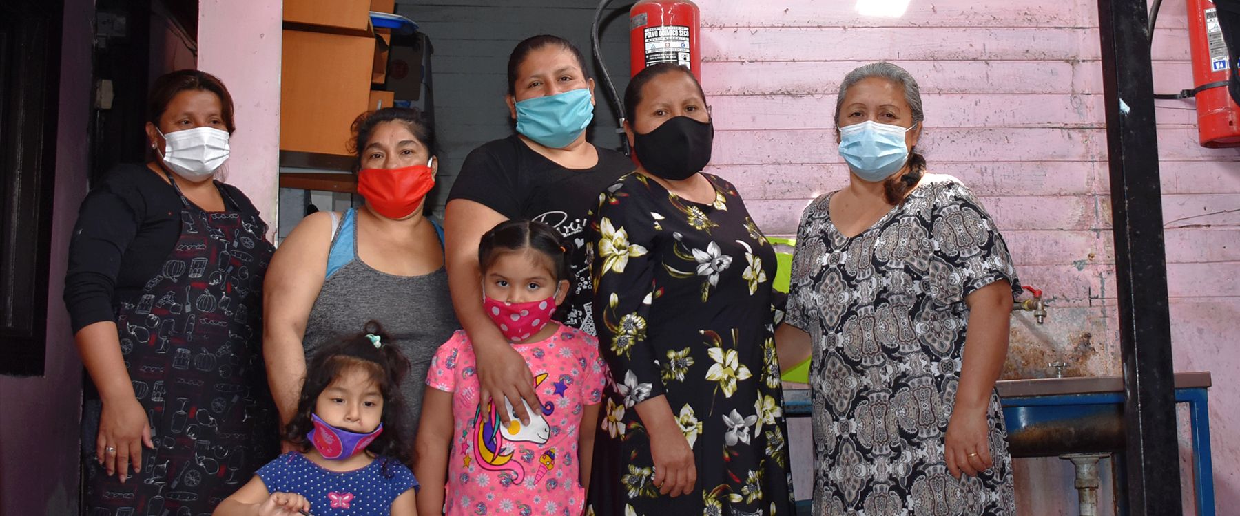Madres y niñas reunidas en el patio de la sede