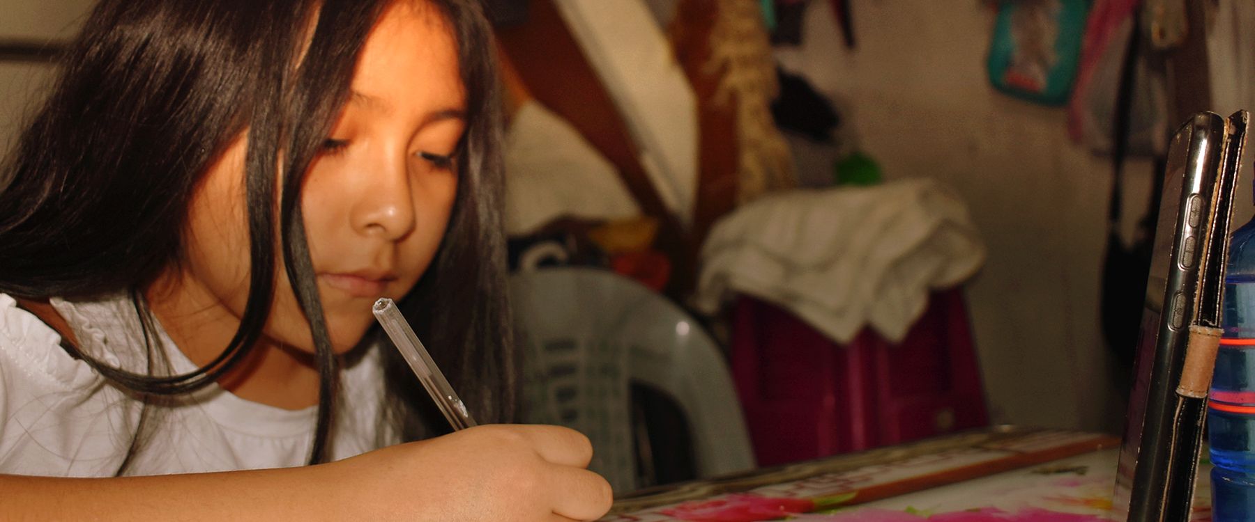 Una niña hace sus tareas en la sede